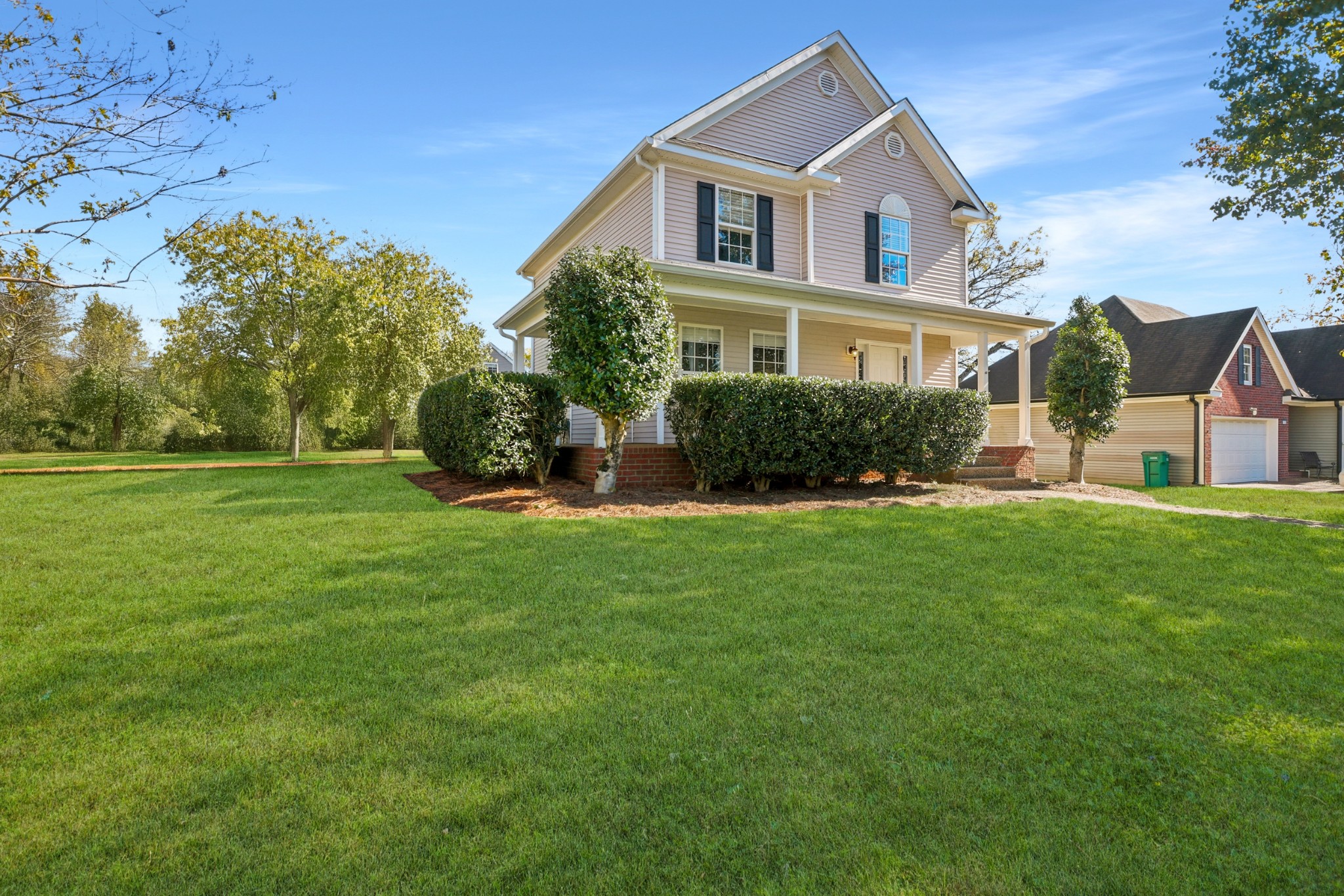a front view of a house with a yard and trees