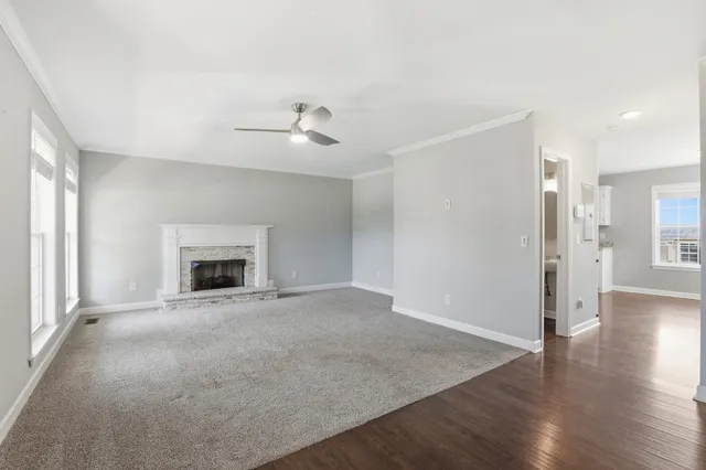 an empty room with wooden floor and fireplace