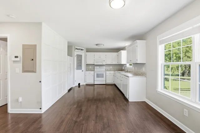 a kitchen with wooden floors and white appliances