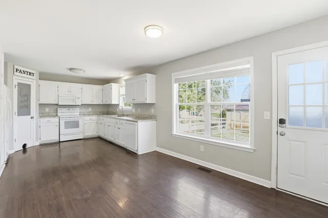 a view of a kitchen with wooden floor and electronic appliances