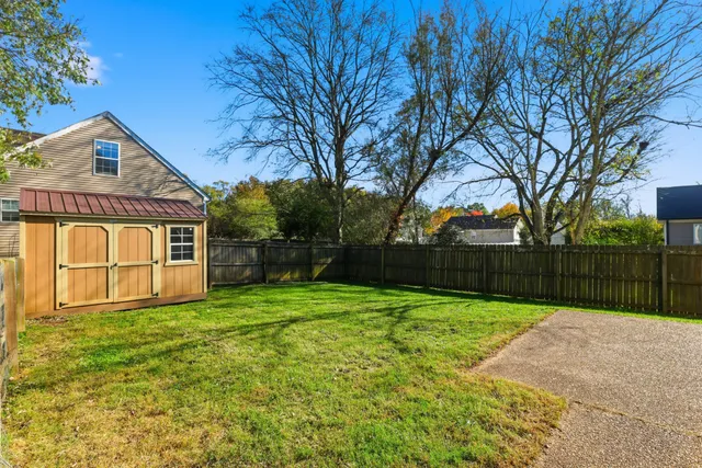 a view of a backyard with a house and large trees