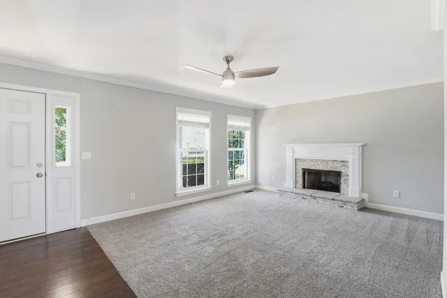 an empty room with windows and fireplace