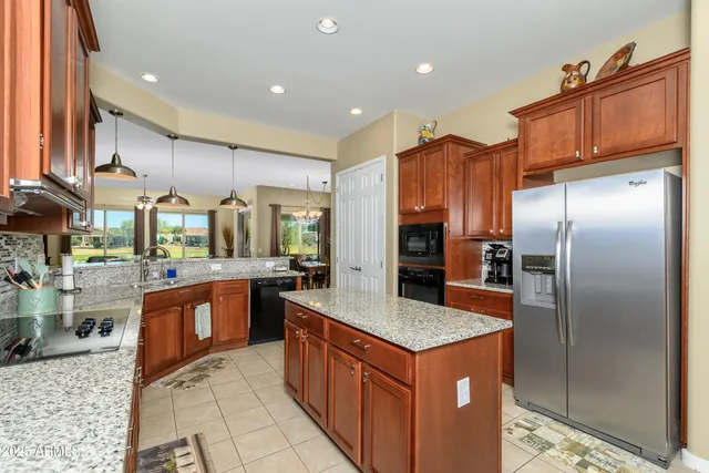 a kitchen with stainless steel appliances granite countertop a refrigerator a sink and a stove