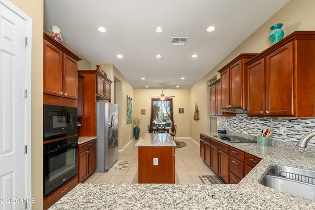 a kitchen with stainless steel appliances granite countertop sink stove refrigerator and cabinets