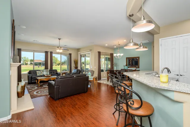 a view of a dining room and livingroom with furniture wooden floor a chandelier
