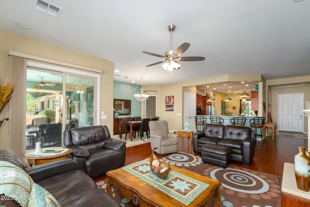 a living room with furniture a chandelier and a large window