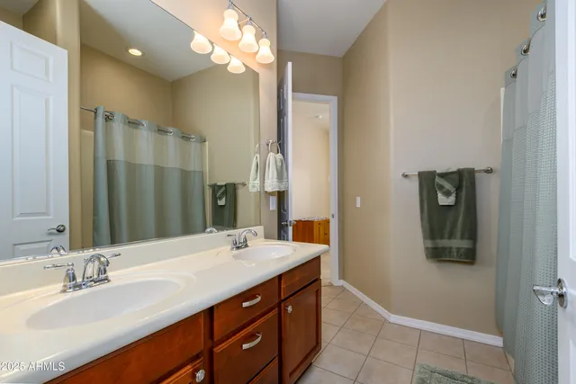 a bathroom with a double vanity sink a mirror and a shower