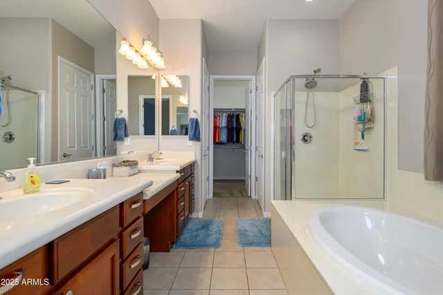 a spacious bathroom with a tub sink shower and mirror