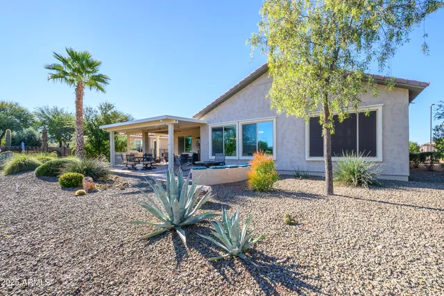 a view of a house with backyard and sitting area
