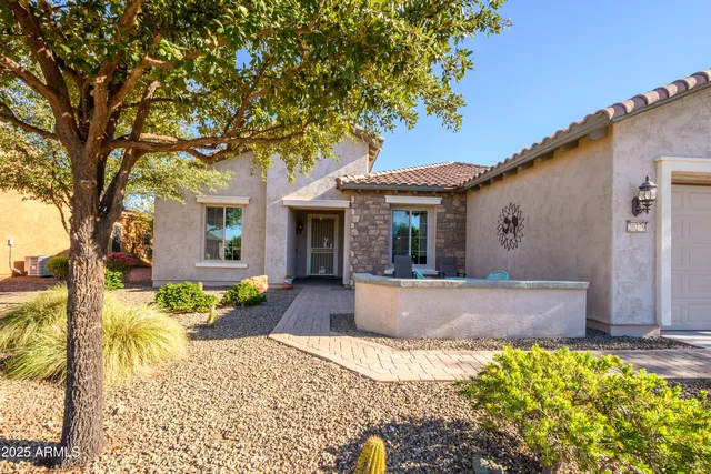 a view of a house with a large tree in the yard