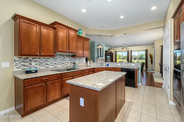 a kitchen with stainless steel appliances granite countertop wooden cabinets a sink and a stove