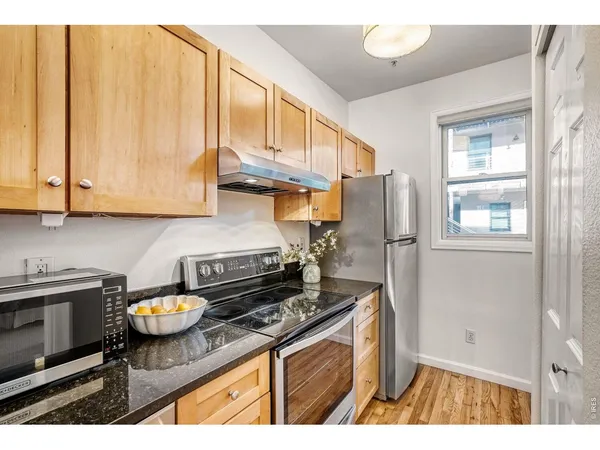 a kitchen with stainless steel appliances granite countertop a sink a stove and cabinets