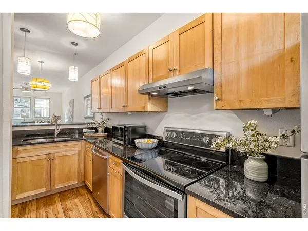a kitchen with stainless steel appliances granite countertop a refrigerator stove and sink