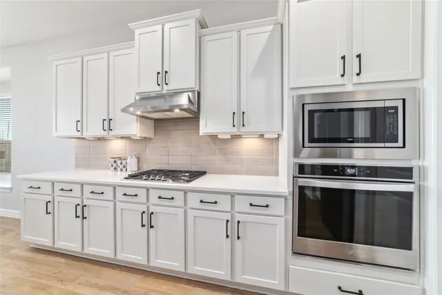 a kitchen with stainless steel appliances granite countertop white cabinets a sink and dishwasher