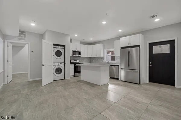 a kitchen with stainless steel appliances a refrigerator sink and cabinets
