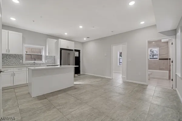 a view of kitchen with refrigerator sink and cabinets