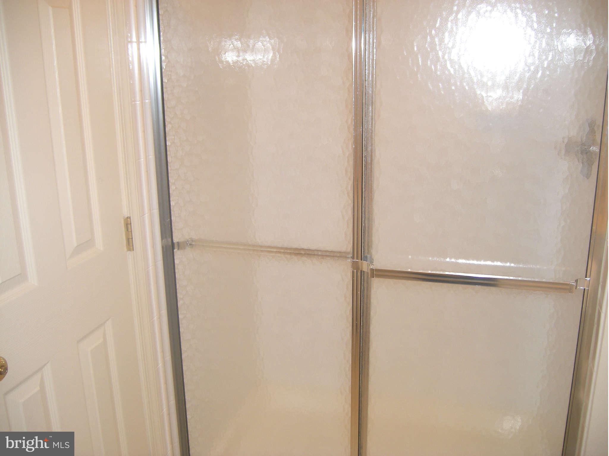 7785 Paddock Way Baltimore, MD 21244 - Photo 27 of 30 a bathroom with a glass shower door