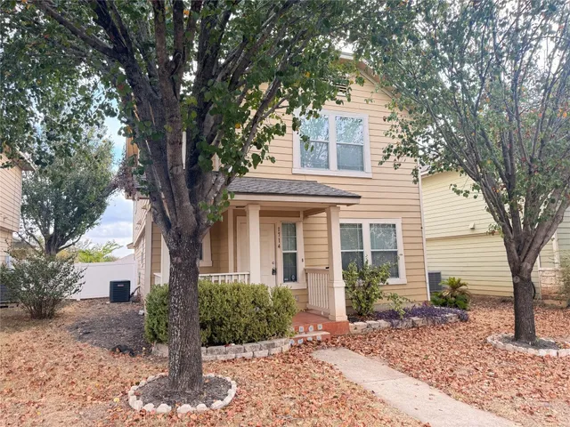 a front view of a house with garden and trees