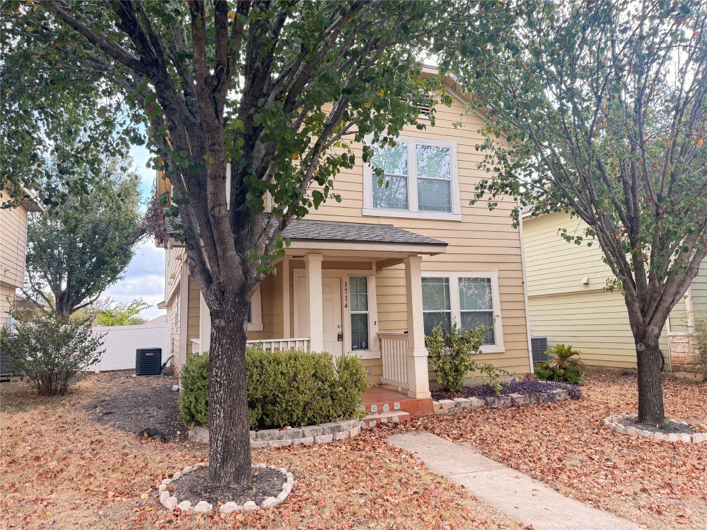 a front view of a house with garden and trees