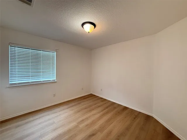 a view of a room with wooden floor and window