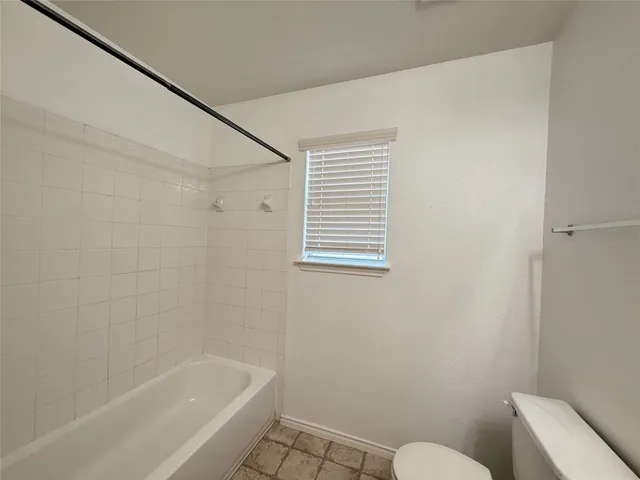 a white bath tub sitting next to a toilet