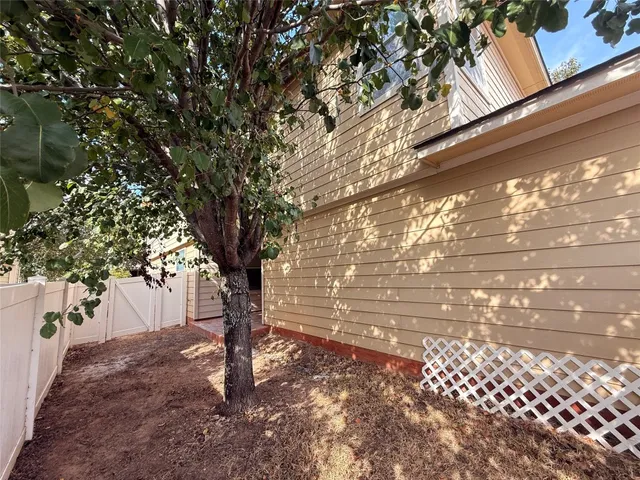a view of a yard with wooden fence