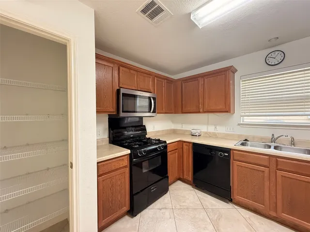 a kitchen with a sink stove top oven and cabinets