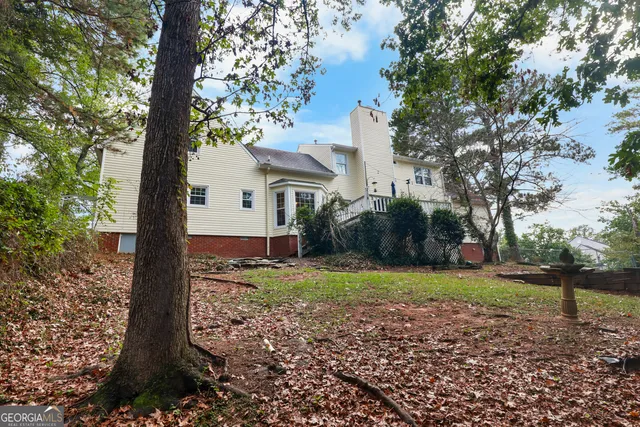 a view of a yard in front of a house with large trees