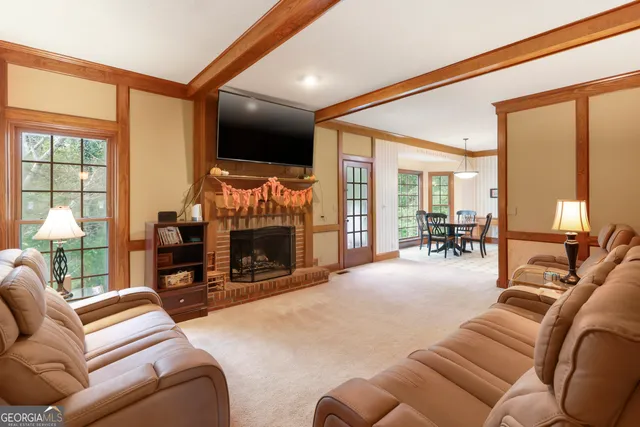 a living room with furniture a large window and a flat screen tv