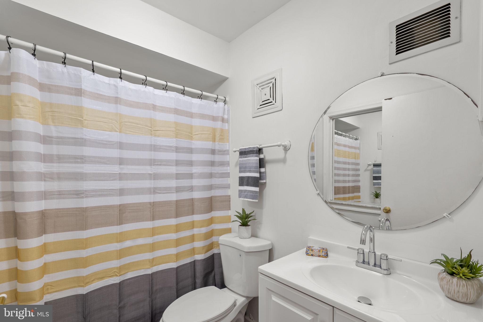 5927 Bayshire Road, Unit 115 Springfield, VA 22152 - Photo 24 of 55 a bathroom with a sink a toilet a mirror and shower curtain