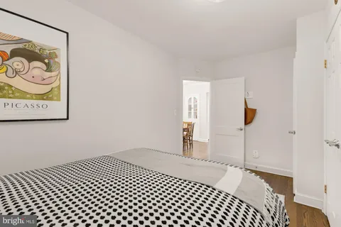 a bedroom with a bed and a painting on the wall