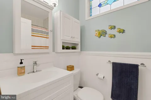 a bathroom with a sink a toilet and a shower curtain