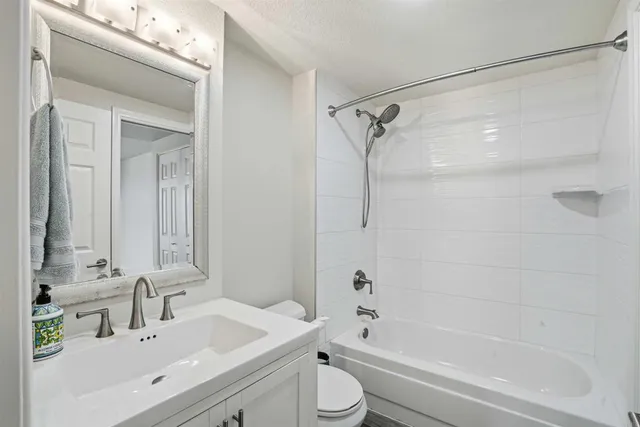 a bathroom with a bathtub shower sink vanity and toilet