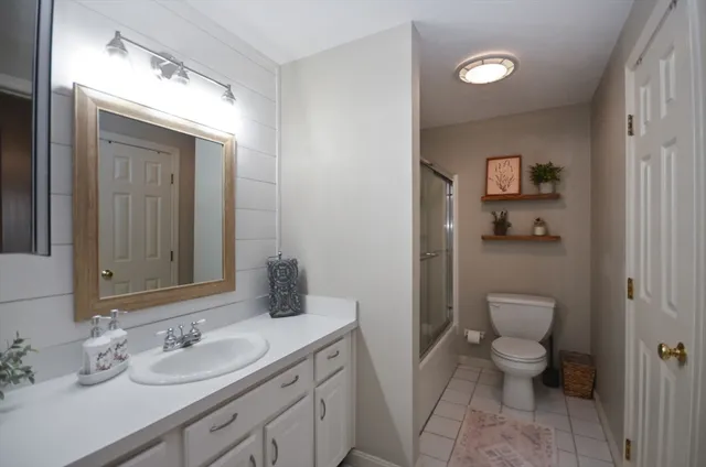 a bathroom with a granite countertop sink a toilet and a mirror