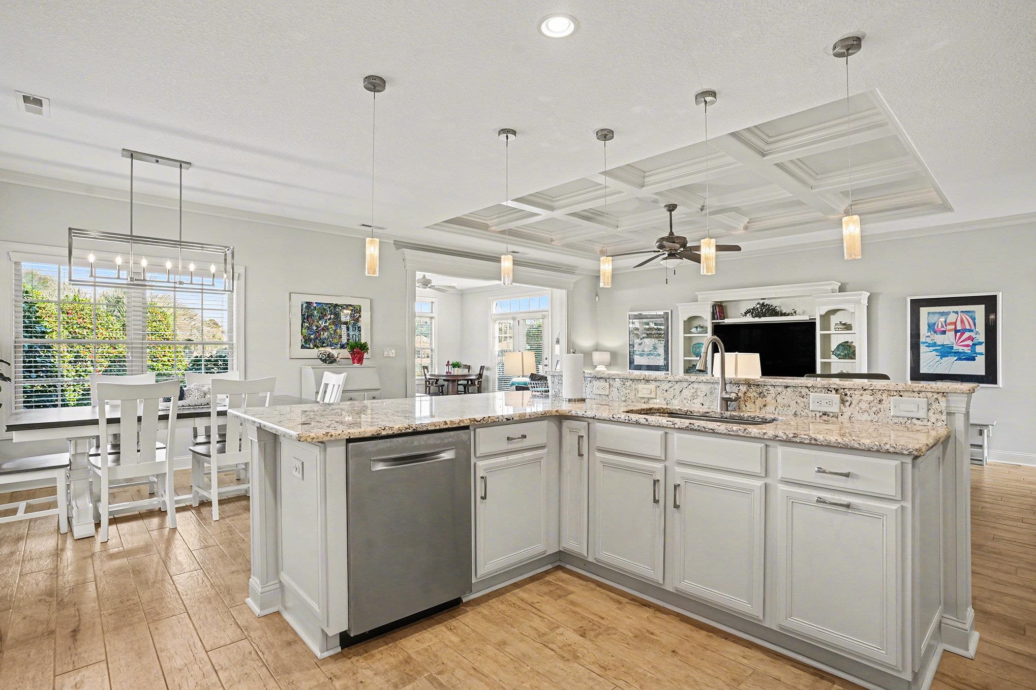 896 Marsala Drive Myrtle Beach, SC 29572 - Photo 13 of 33 Kitchen with coffered ceiling, stainless steel dishwasher, hanging light fixtures, light stone countertops, and white cabinets