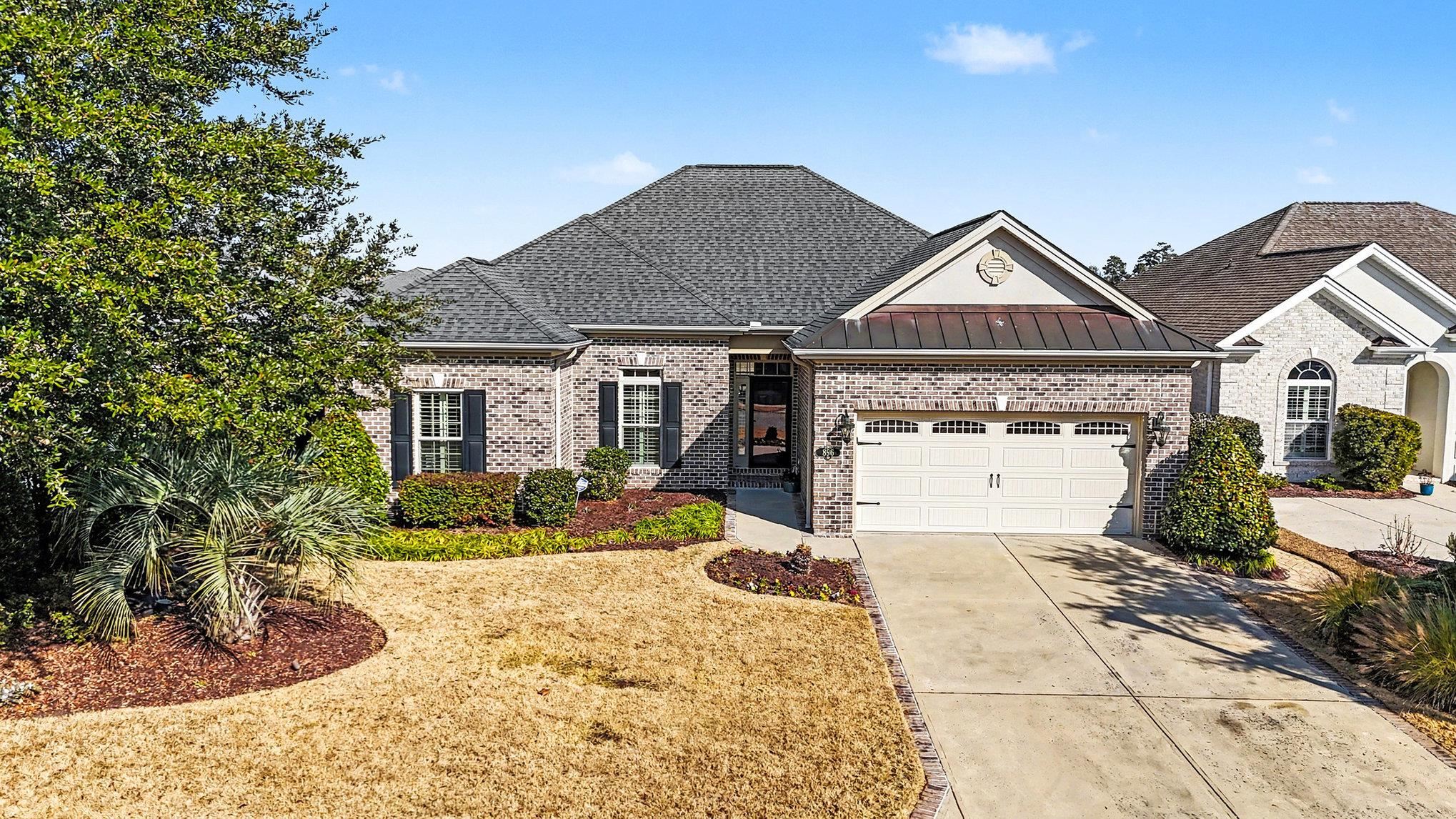 896 Marsala Drive Myrtle Beach, SC 29572 - Photo 2 of 33 View of front of home featuring a standing seam roof, brick siding, a metal roof, driveway, and a garage