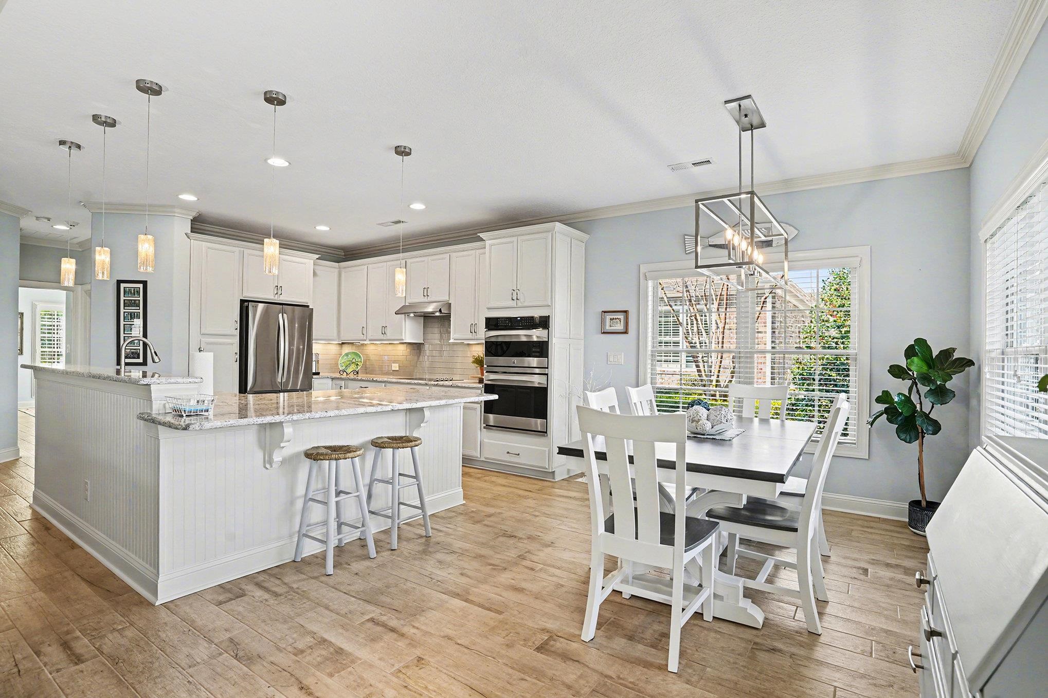 896 Marsala Drive Myrtle Beach, SC 29572 - Photo 10 of 33 Kitchen featuring ornamental molding, decorative light fixtures, appliances with stainless steel finishes, white cabinetry, and a kitchen breakfast bar
