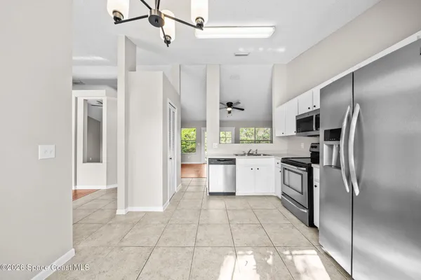 a kitchen with granite countertop a refrigerator and a stove top oven