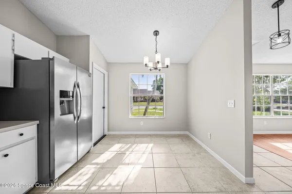 a view of a refrigerator in kitchen and entryway with window