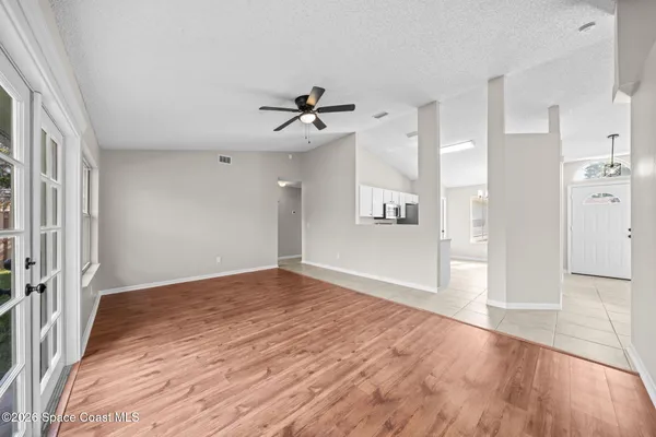 a view of a big room with wooden floor and a kitchen