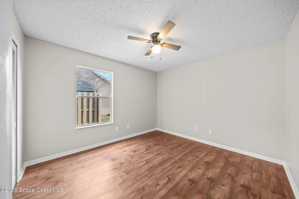 an empty room with windows and fan