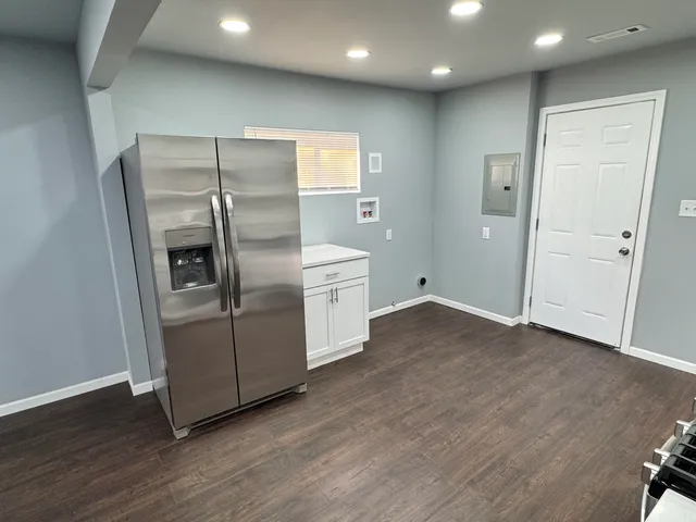 a kitchen with stainless steel appliances a refrigerator and wooden floor
