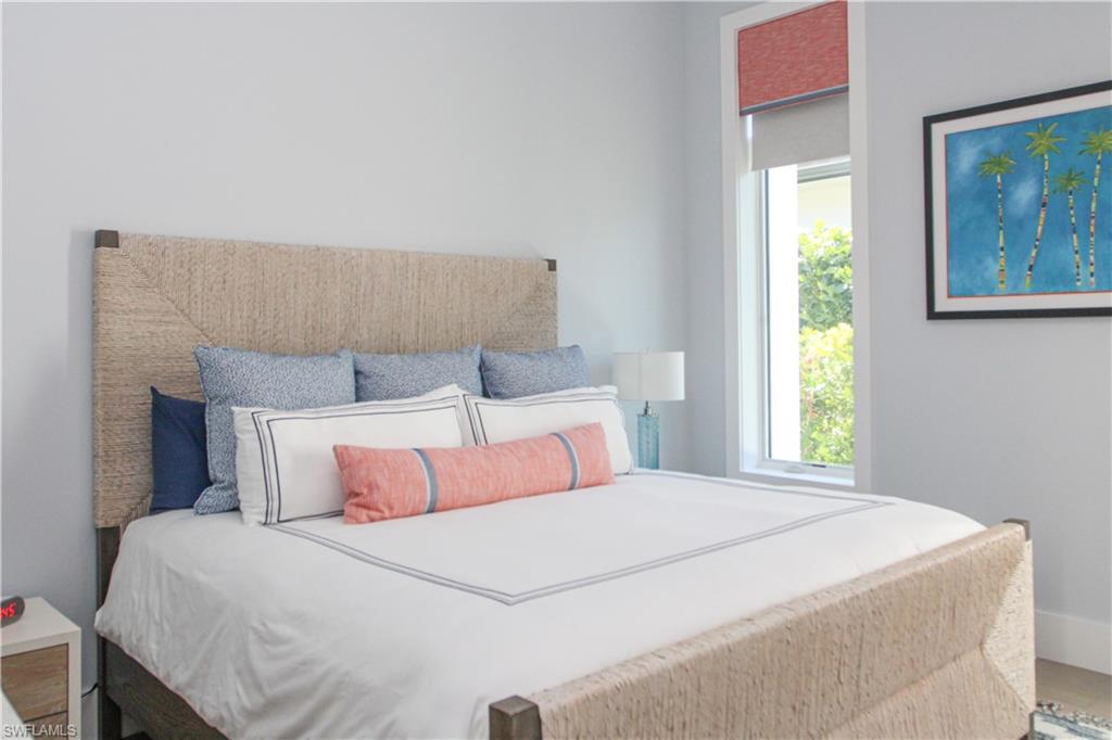 3123 Crayton Road Naples, FL 34103 - Photo 23 of 50 a bedroom with a bed and a painting on the wall