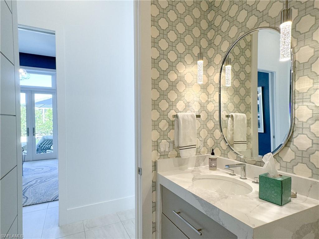 3123 Crayton Road Naples, FL 34103 - Photo 33 of 50 a bathroom with a granite countertop sink and a mirror