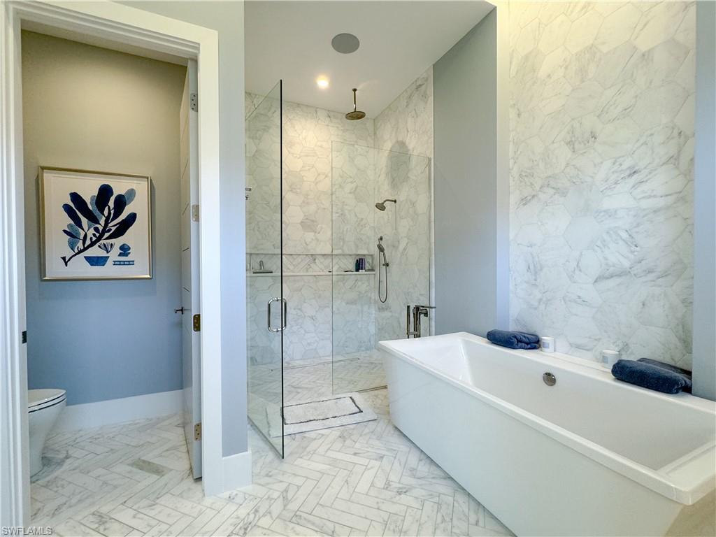 3123 Crayton Road Naples, FL 34103 - Photo 38 of 50 a bathroom with a tub shower and toilet