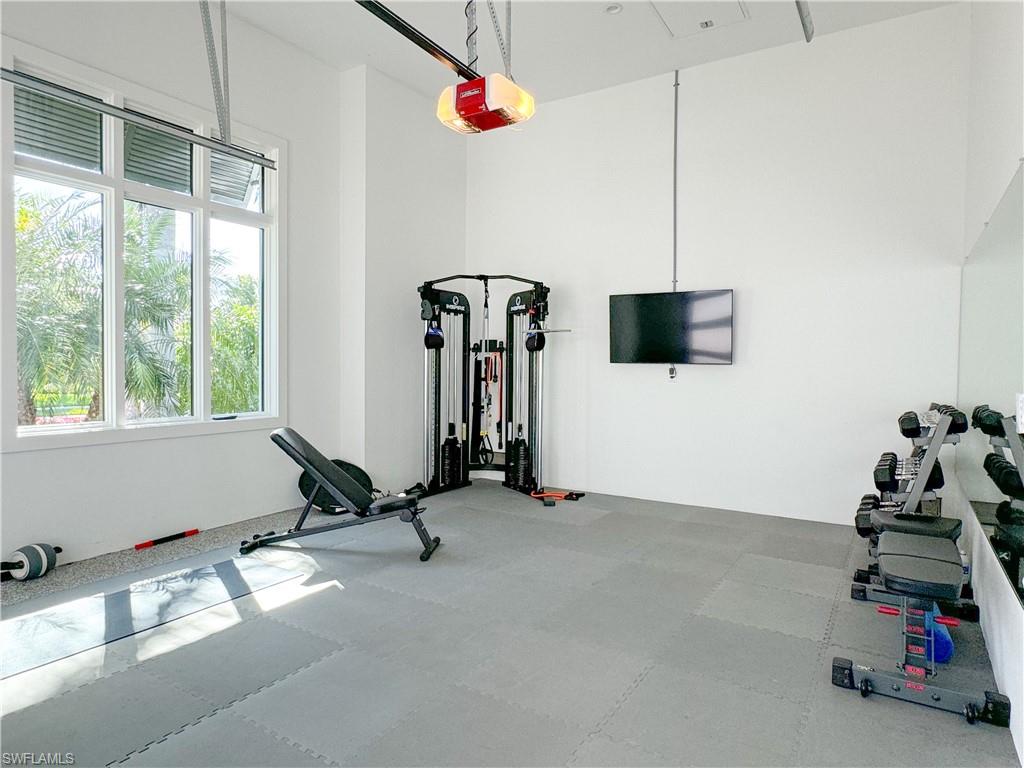 3123 Crayton Road Naples, FL 34103 - Photo 46 of 50 a room with gym equipment and a flat screen tv