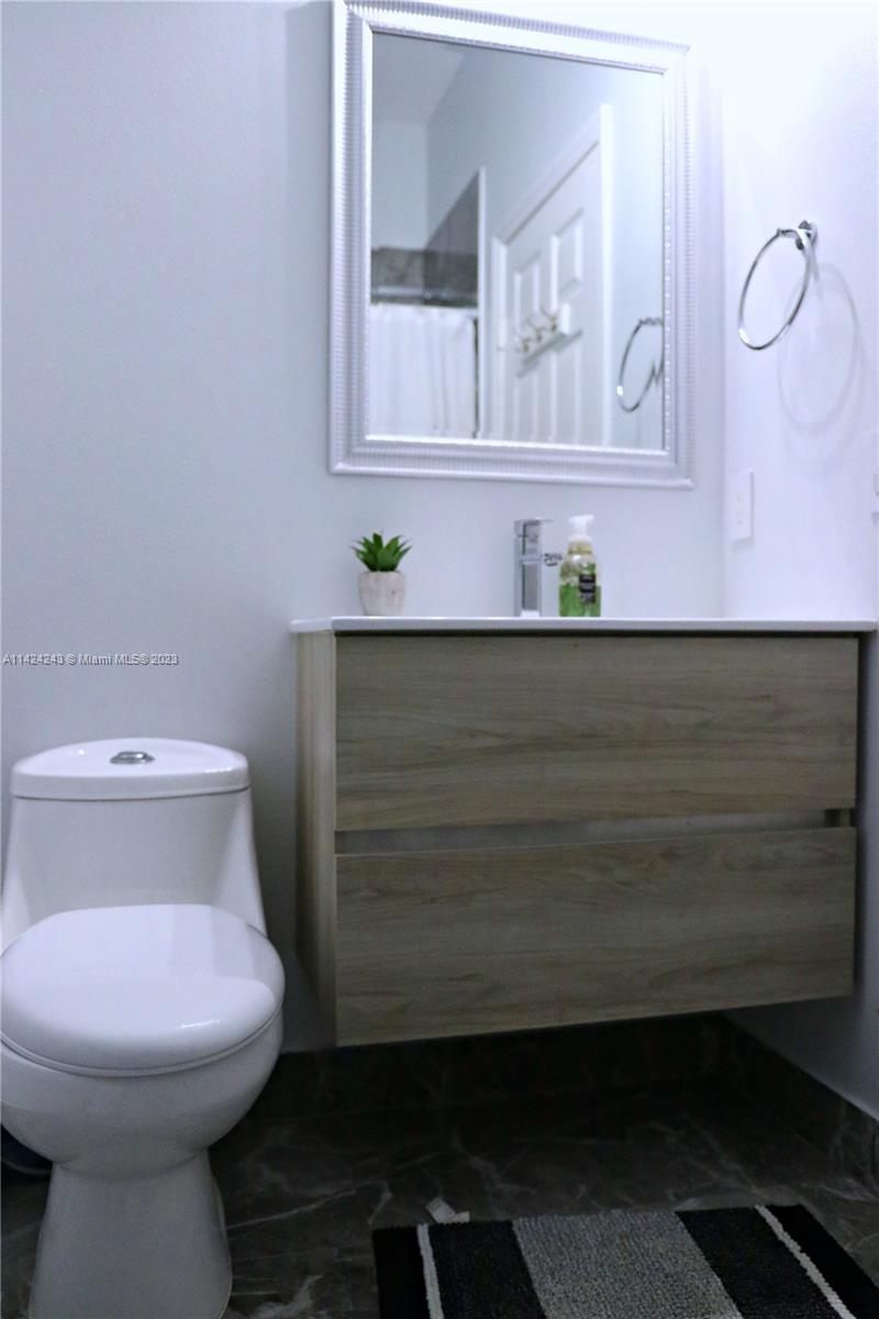 4929 Southwest 140th Terrace, Unit 5 Miramar, FL 33027 - Photo 12 of 24 a bathroom with a toilet sink and mirror