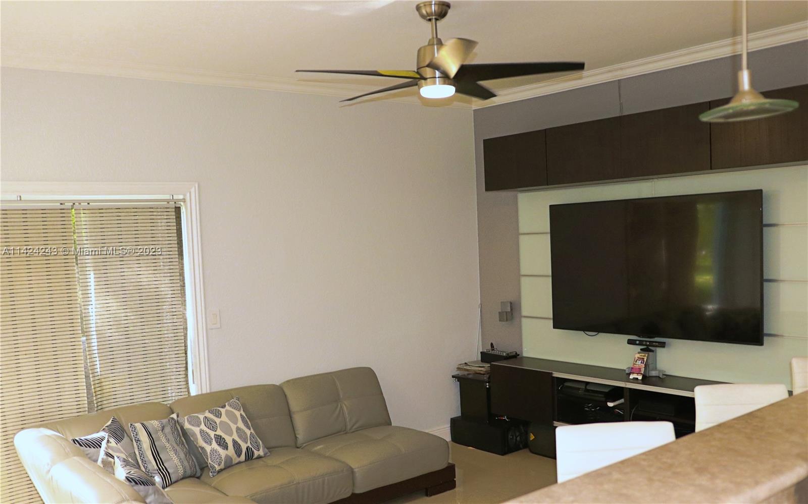4929 Southwest 140th Terrace, Unit 5 Miramar, FL 33027 - Photo 6 of 24 a living room with furniture and a flat screen tv