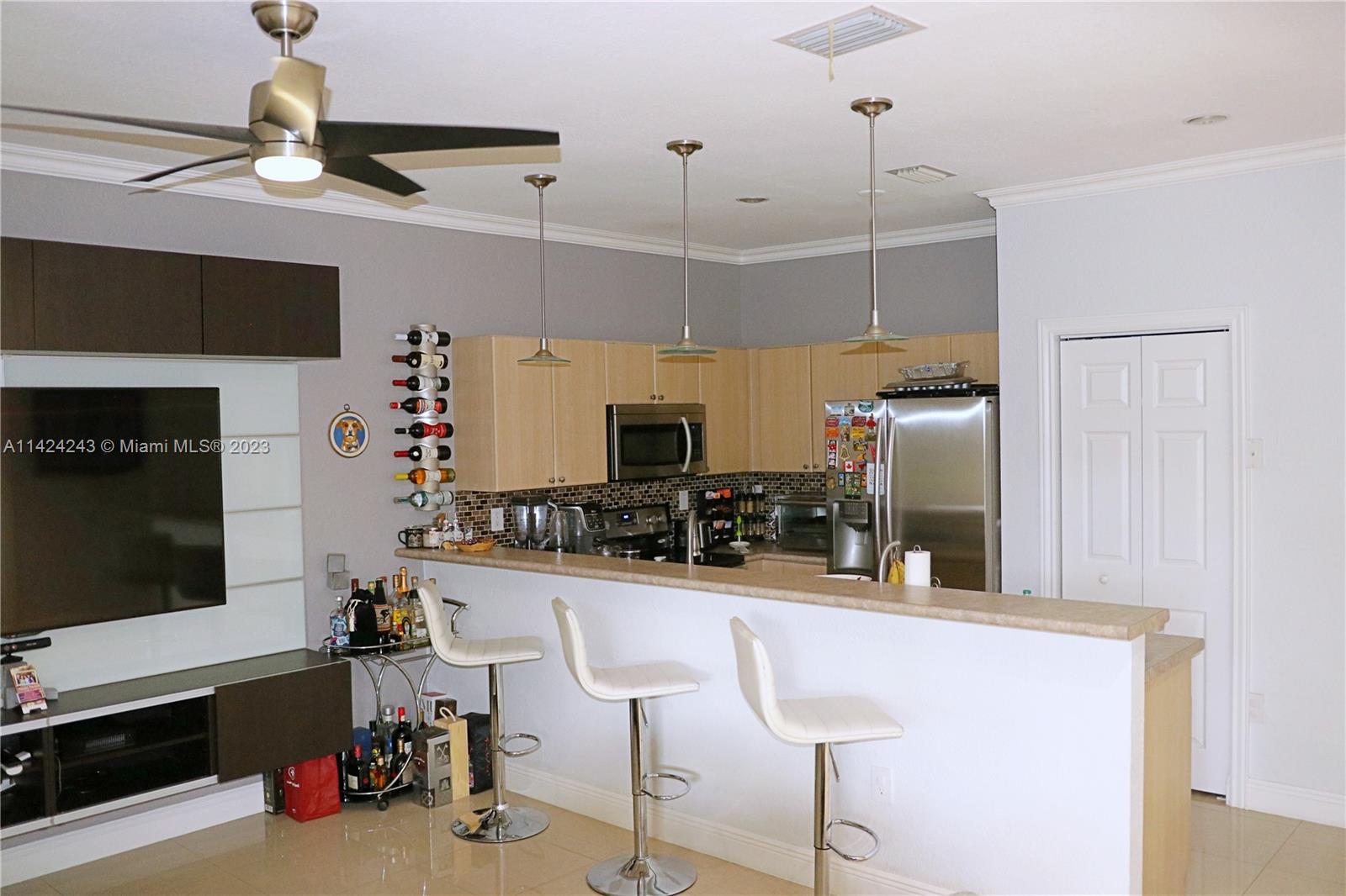 4929 Southwest 140th Terrace, Unit 5 Miramar, FL 33027 - Photo 7 of 24 a kitchen with stainless steel appliances kitchen island granite countertop a sink and cabinets