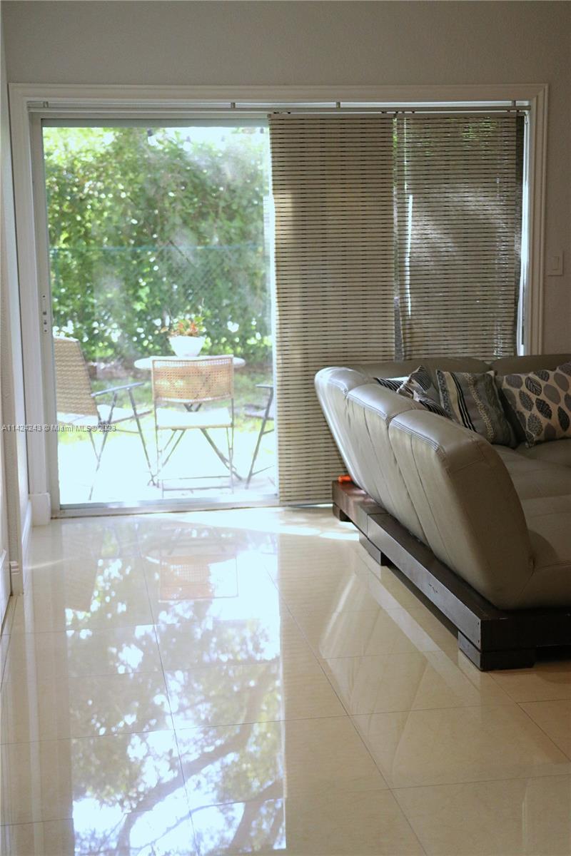 4929 Southwest 140th Terrace, Unit 5 Miramar, FL 33027 - Photo 9 of 24 a living room with a couch and a large window
